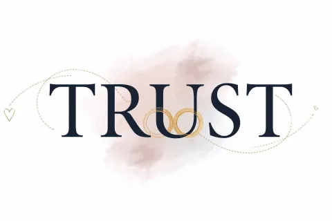 Word TRUST with two interlocked gold wedding rings and decorative heart and swirl accents on a soft pink background