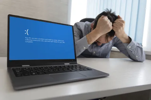 a man with a mask on his face looking at a laptop