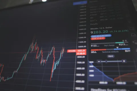 Bitcoin price chart on digital screen with candlestick graph and trading details in USD.