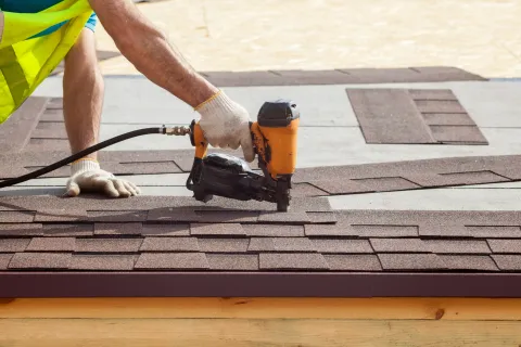 a personal nailing shingles to a roof
