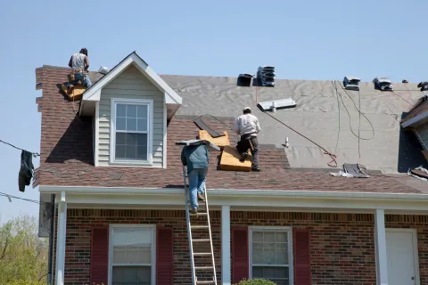 a group of men on top of a house