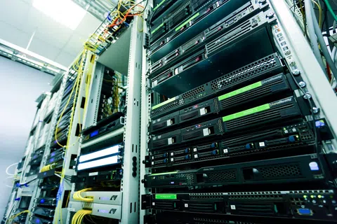 Close-up of server racks with network cables in a data center environment focused on hardware and connectivity.