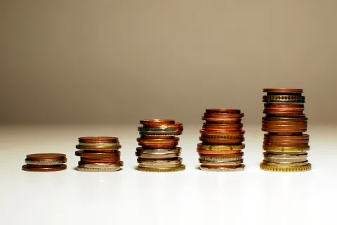 Stacks of mixed coins arranged in ascending order representing financial growth and saving money.