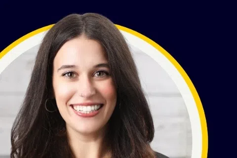 Smiling young woman with long dark hair in front of a yellow and white circular frame on a dark blue background