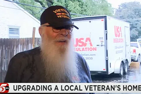 Elderly Vietnam veteran with a long white beard shares about home upgrades outside on a rainy day.