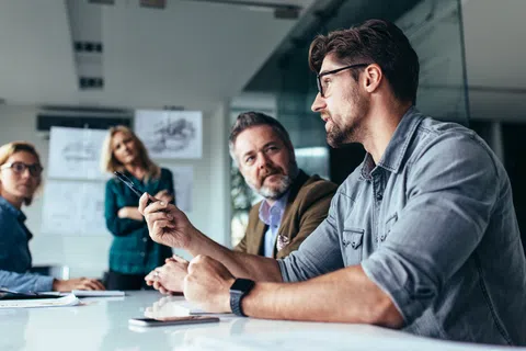 Team of professionals engaged in a business meeting discussing ideas in a modern office setting