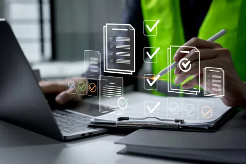 Person working on laptop with digital checklist icons and documents, symbolizing task management and productivity.