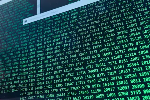 Close-up of a computer screen displaying green numerical code and data entries on a dark background.