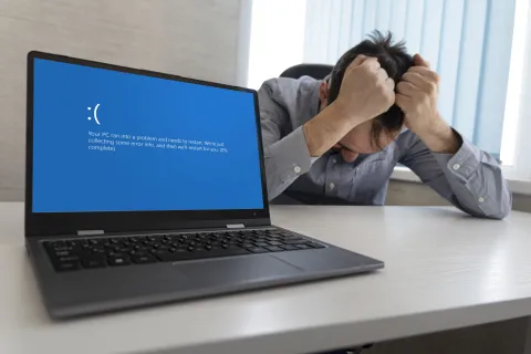 a man with a mask on his face looking at a laptop