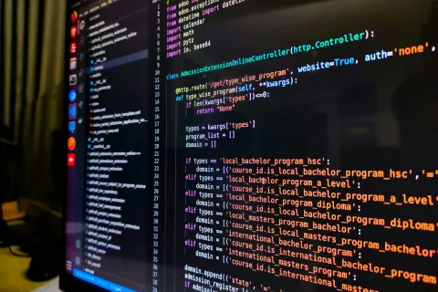 Computer screen displaying Python code for a web controller handling program types and admissions.