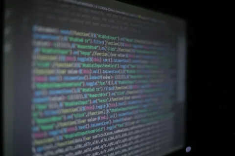 Blurred colorful programming code displayed on a dark screen with various functions and filters.