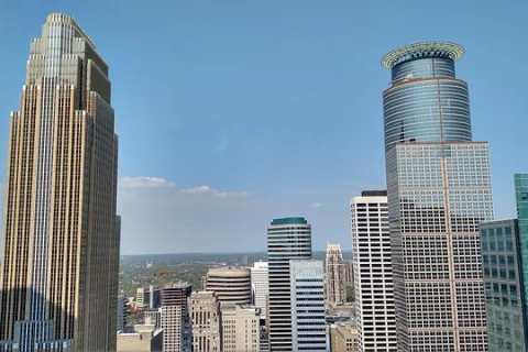 Downtown skyline featuring tall modern skyscrapers under a clear blue sky in a major city