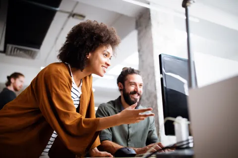 a woman and a man looking at a computer screen