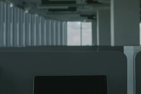 Laptop on office desk displaying the words CYBER SECURITY in red on black screen in a modern workspace.
