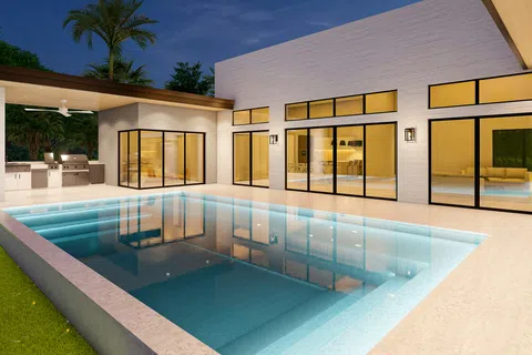 Modern house exterior with large glass windows and a lit swimming pool at night under a clear sky.