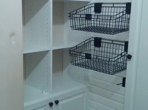 a white pantry with baskets