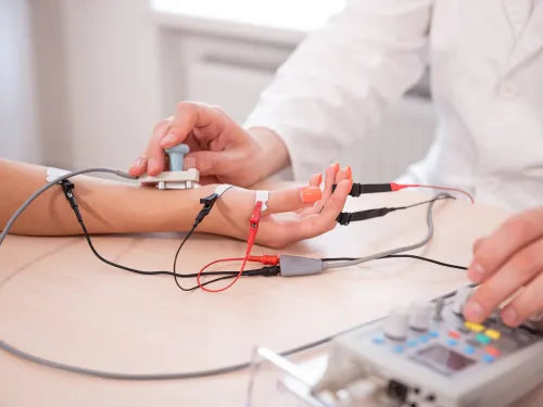 Doctor performing a nerve conduction study on a patient's arm