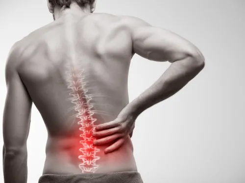 Man holding lower back with highlighted spine indicating pain or injury in the lumbar region.