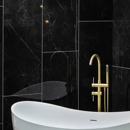 Modern white bathtub with gold faucet against sleek black marble wall tiles in a luxury bathroom