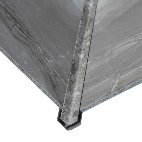 Close-up of a corner edge of grey marble slabs joined with a metal corner protector on a white background