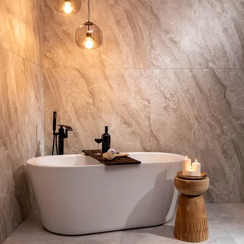 Modern bathroom with freestanding white bathtub, wooden candle holder, and warm ambient lighting