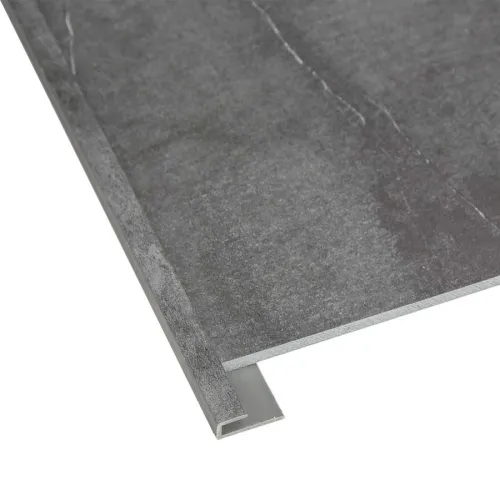 Close-up of a dark gray tile with an L-shaped metal edge trim for protecting corners and edges.