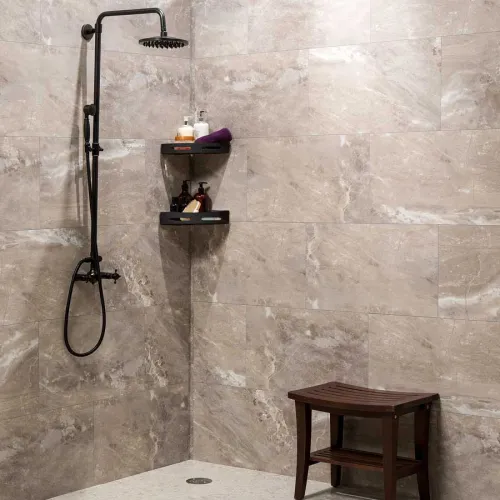 Modern shower with black fixtures, marble tile walls, corner shelves with toiletries, and a wooden shower bench.