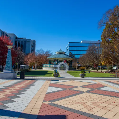 a courtyard with statues and buildings in the background