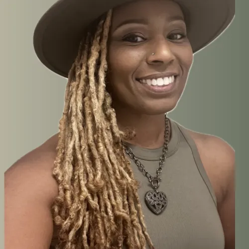 a woman with long hair and a hat smiling