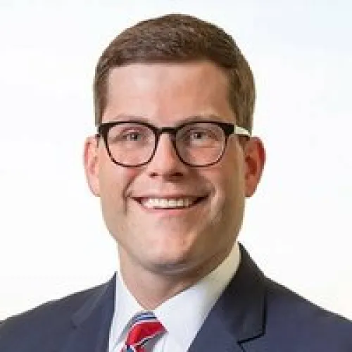 a man wearing glasses posing for the camera