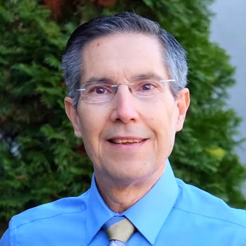a man wearing glasses and a blue shirt