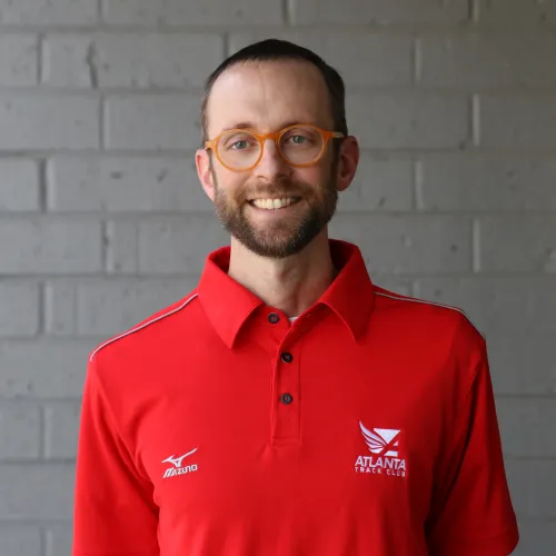 a man wearing glasses posing for the camera