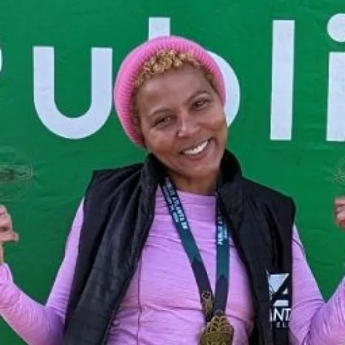 a person posing in front of a green wall with a sign