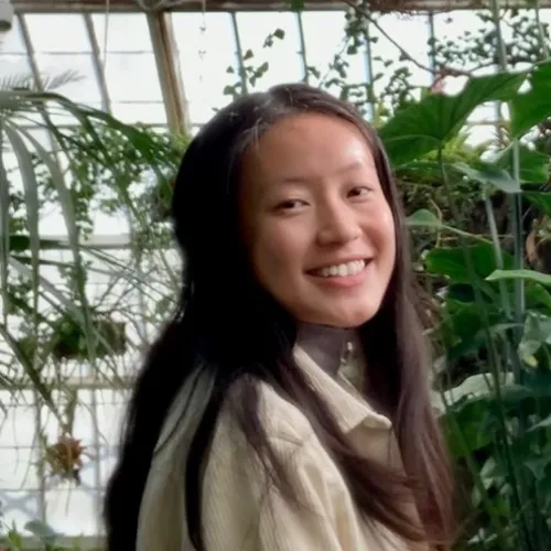 a woman standing in a greenhouse