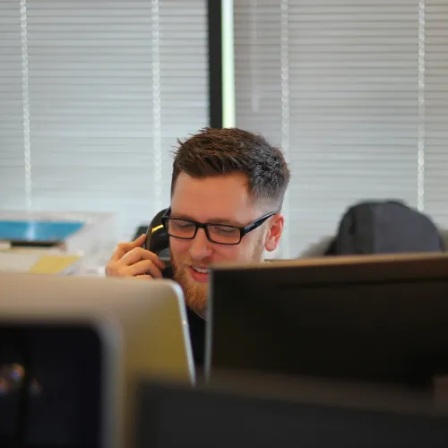 a man with a beard sitting at a desk with a computer