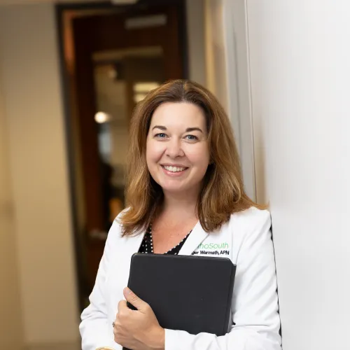 a person in a white coat holding a black binder