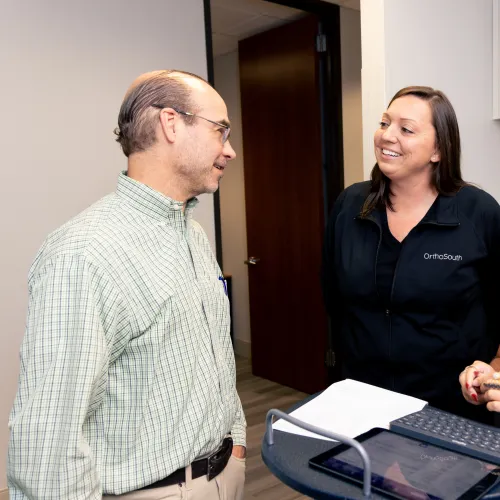 A dentist consulting with two hygienists in a modern office setting.