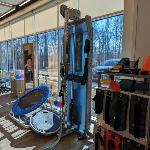 A joyful senior man engages in physical therapy with a smiling female instructor using a resistance band.