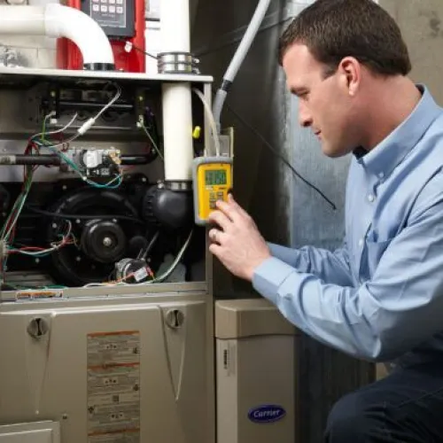 Technician inspecting a furnace with diagnostic equipment in a home setting.