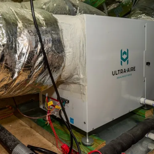Indoor air quality system Ultra-Aire dehumidifier installed with insulated HVAC ductwork and wiring in basement.