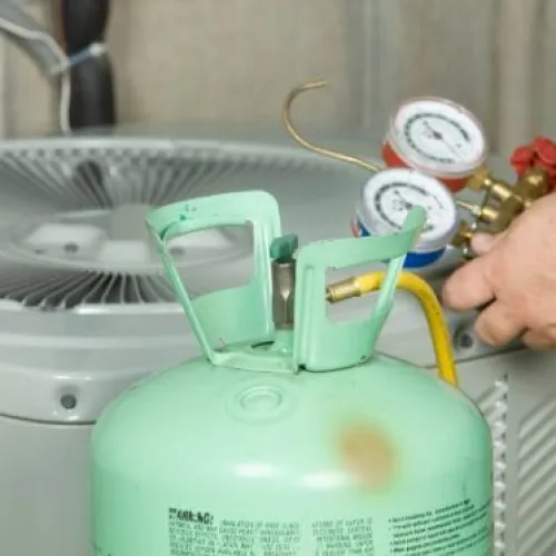 Technician re-charging a condenser unit with new refrigerant