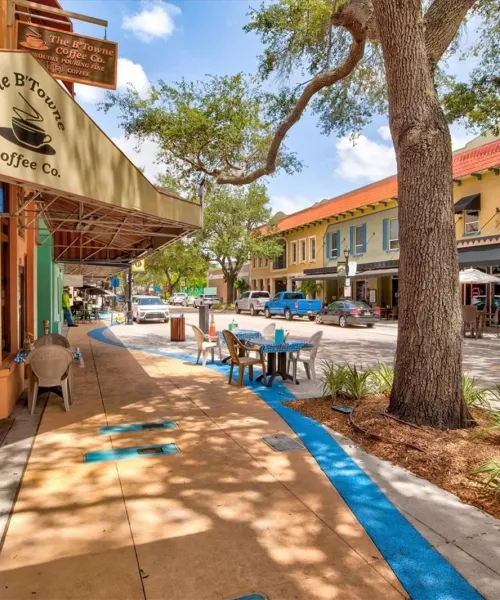 a sidewalk with tables and chairs