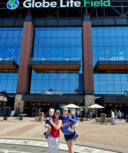 a person holding a baby in front of a building