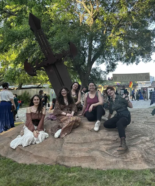 a group of people sitting on a rock in a park