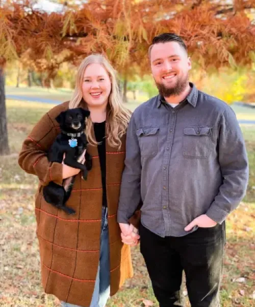 a man and woman holding a dog