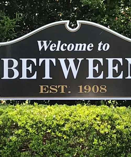 a sign in front of bushes