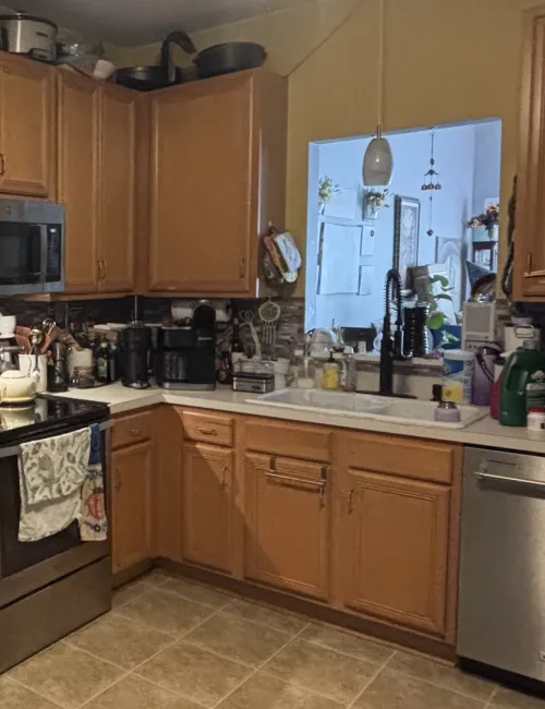 Cozy kitchen with wooden cabinets, stainless steel appliances, and various appliances on the countertops.