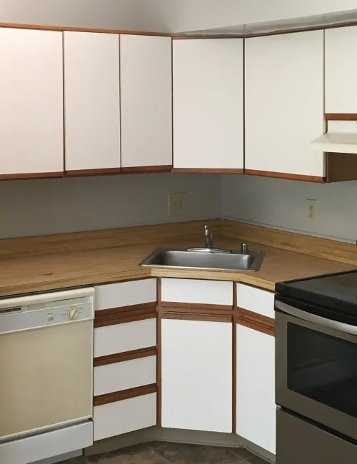 U-shaped kitchen with white cabinets, wooden countertops, stainless steel oven, white refrigerator, and dishwasher