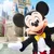 Mickey Mouse in classic attire greeting visitors in front Cinderella's castle at Walt Disney World