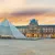 Sunset view of the Louvre Museum with its glass pyramid and historic architecture in Paris, France.